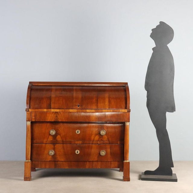 Early 19th-century Empire walnut bureau, featuring an elegant and functional design. The front has three drawers,...