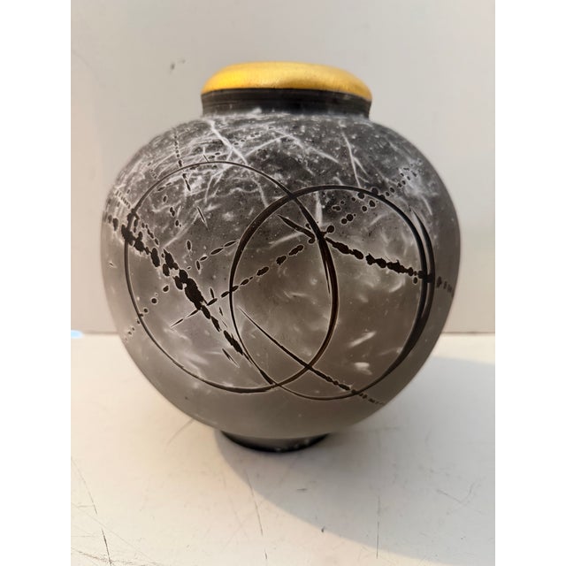 Vintage studio pottery vase featuring a rounded, sculptural form with a striking black and gray drip glaze finish. This...