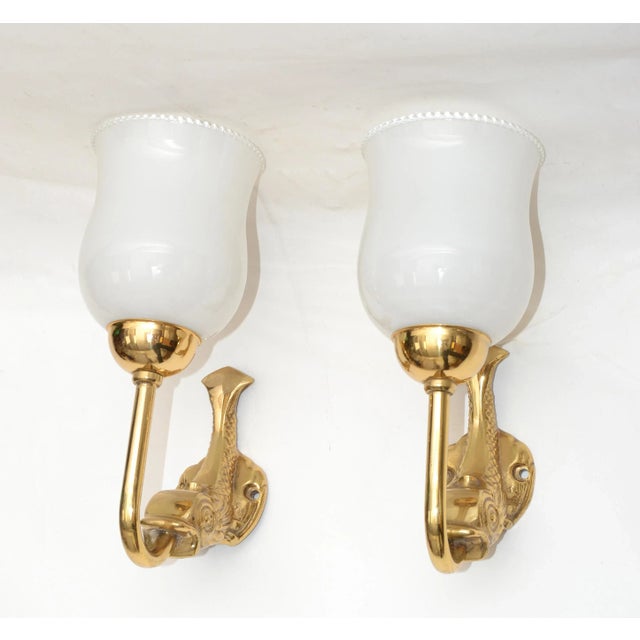 Superb pair of Maison Lancel brass dolphin sconces, wall lights with original white ruffled Opaline Glass Shade. These...