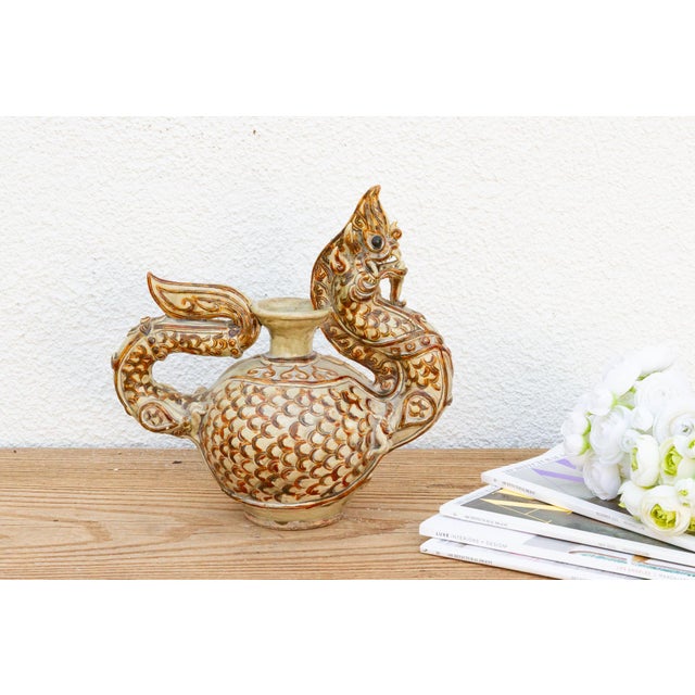 A stunning piece of Southeast Asian craftsmanship, this Antique pottery ewer features a sinuous dragon form molded into...