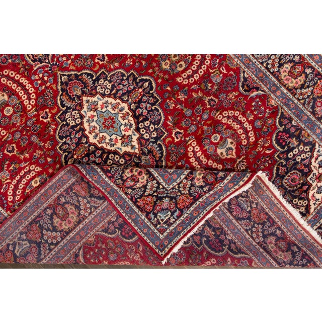 Beautiful vintage Persian Tabriz hand-knotted wool rug with a ruby-red field. This piece has a multi-color accent in an...