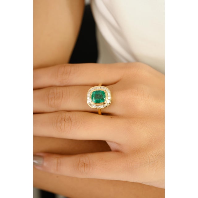 Elegantly crafted in 18k yellow gold, this stunning ring showcases a vivid 1.72-carat cushion-cut emerald at its center —...