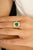 Elegantly crafted in 18k yellow gold, this stunning ring showcases a vivid 1.72-carat cushion-cut emerald at its center —...