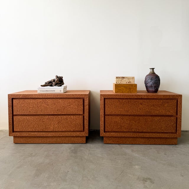 A striking pair of vintage 1980s Postmodern nightstands featuring richly figured burl-style veneer with dramatic movement...