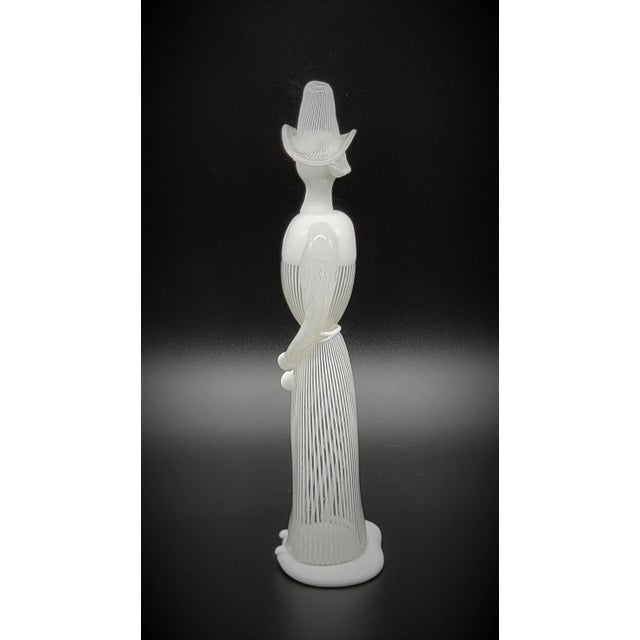 Offered for sale is a very rare figurine of a woman in lattimo (milky glass) with hat and dress in lattimo filigree....