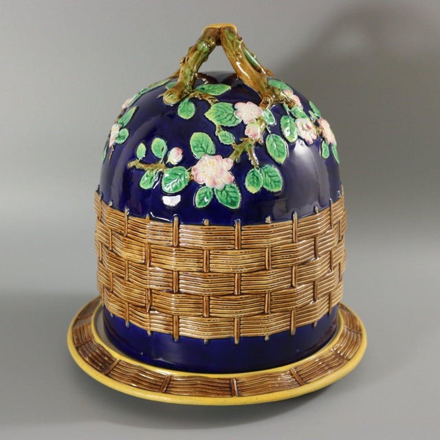 George Jones Majolica cheese keep which features a branch handle with apple blossoms. Basketweave to the sides. Cobalt...