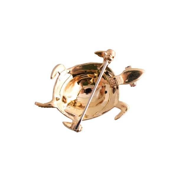 Mid 20th Century This brooch is crafted in 14k yellow gold. The piece features a detailed turtle design. Adorned with red...