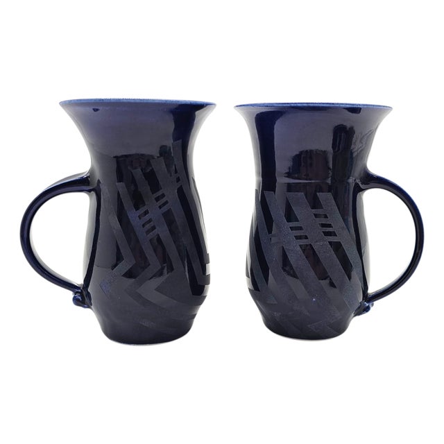 A striking studio pottery trio by Marianne Weinberg Benson, featuring two hand-thrown mugs and a covered box in deep...