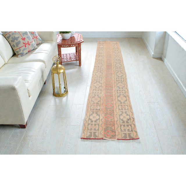 This is a vintage Turkish Oushak rug from the Mid 20th Century. The piece was hand-knotted.