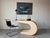 A striking 1980s Postmodern console table featuring a bold geometric waterfall silhouette with sculptural curves and a...