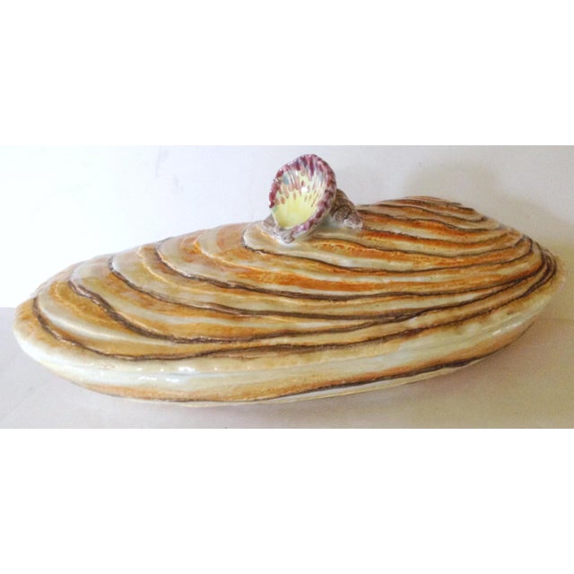 This large covered Italian serving dish is fashioned in the image of a mussel and the handle on the lid is two smaller...