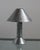 Postmodern table lamp by Ron Rezek, circa 1980s. The galvanized steel frame features a removable outer shade accented by a...