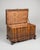 A beautifully crafted antique blanket chest featuring rich wood grain, hand-carved paneling, and striking original iron...