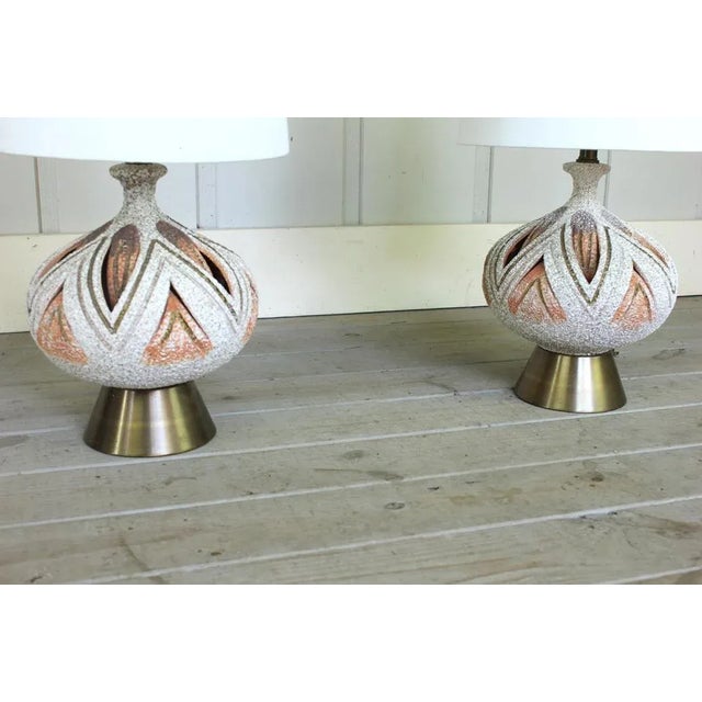 Stylish sculptural pair of Mid Century Modern lamps with a textured orange/white/gold finish. They are in very good...