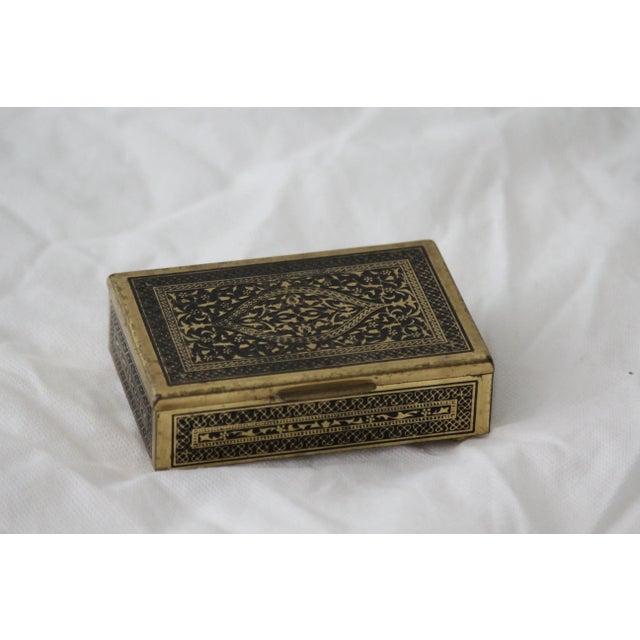 Gold and black jewelry or cigarette case. Brass, wood inside. Dimensions: Length 4.3" / 11.4 cm Width 2.7" / 7.8 cm Height...