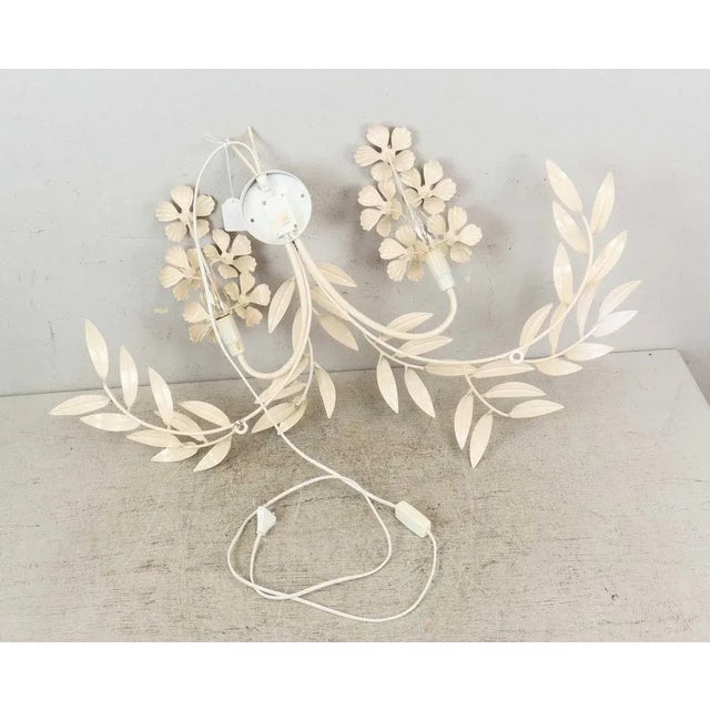 Lacquered metal frame. Decor in the form of branches with leaves and flowers. Pompous wall sconce with branches and leaves...