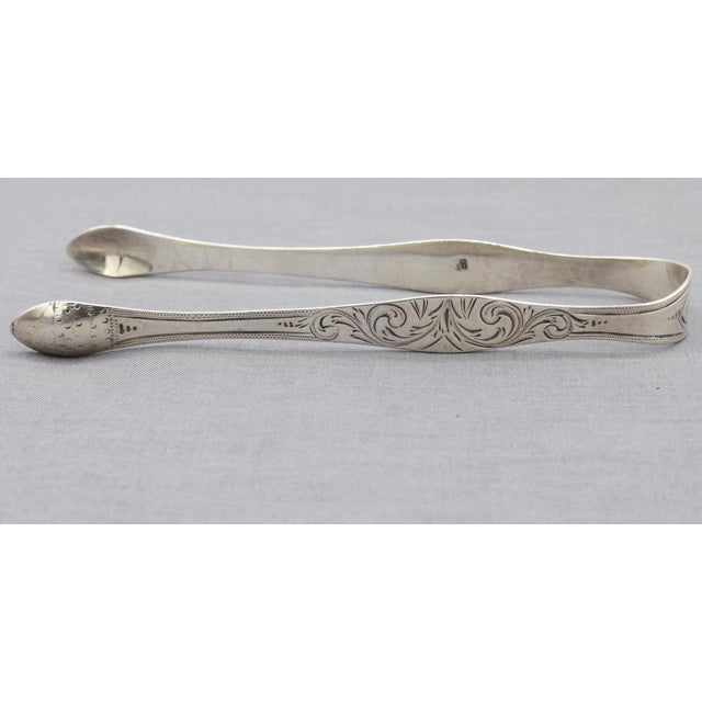 Sterling silver sugar tongs by Peter & Ann Bateman, 1798, London. Bow form decorated with swirling bright-cut work. Old,...