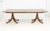 Baker Furniture Mahogany Twin Pedestal Extending Dining Table, each pedestal with gilt metal foliate motif mount and four...