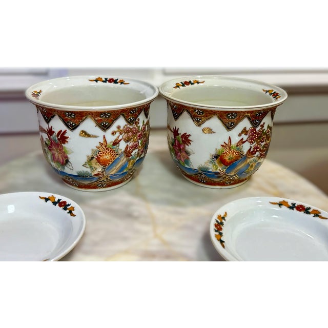 A unique pair of hand painted chinoiserie planters from the 1970s. The planters have intricate detailed moriage like...