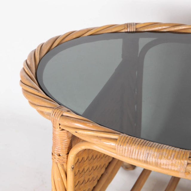 Beautiful woven rattan and glass table from the 1970s. Beautiful weaving, glass top. Very good condition.