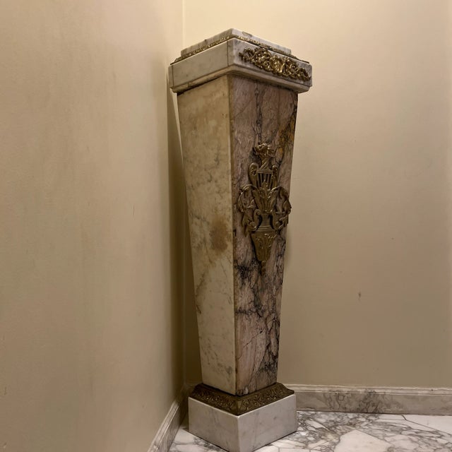 An ideal statement pedestal for a living room, entryway, or art display. Made of white Carrara marble. The front panel...