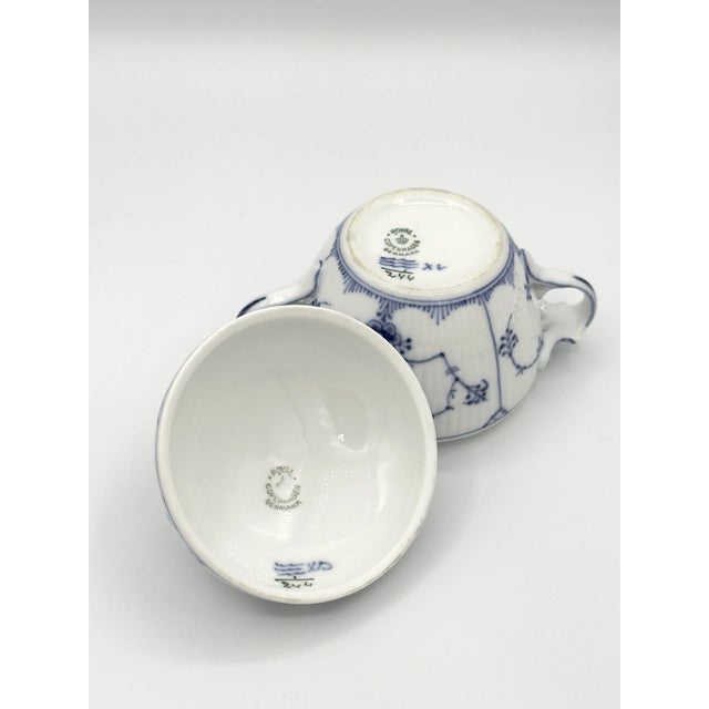 Classic Royal Copenhagen Blue Fluted covered sugar bowl, crafted in fine Danish porcelain. This timeless piece features...