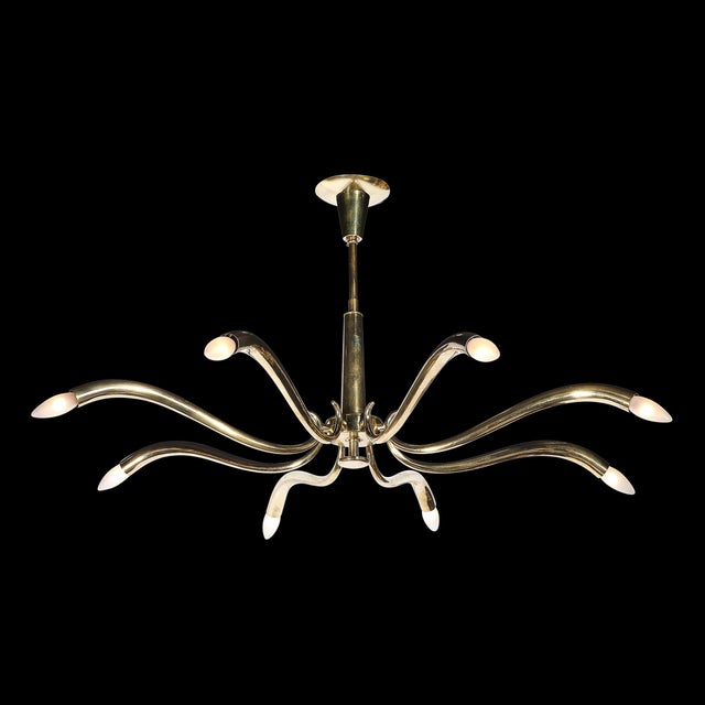 This luminous Mid-Century Polished Brass 8-Arm Sculptural Chandelier by Oscar Torlasco originated in Italy, circa 1955....