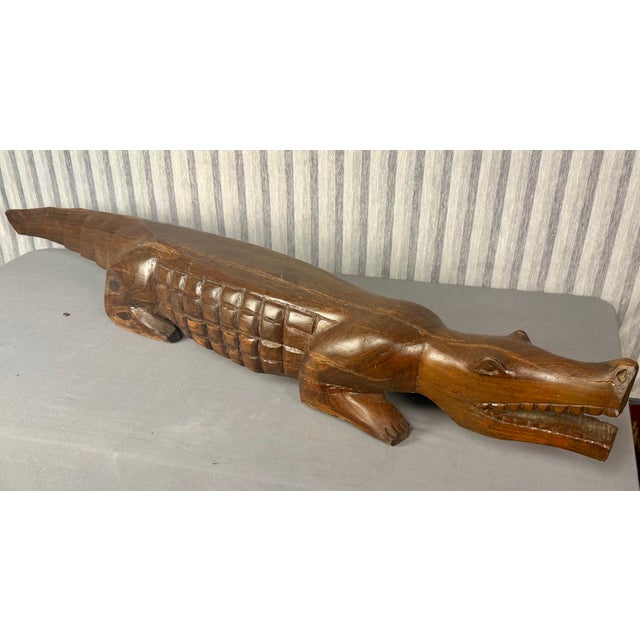 Carved from a single log, this massive hand carved dark wood alligator or crocodile sculpture is truly impressive! 50"...