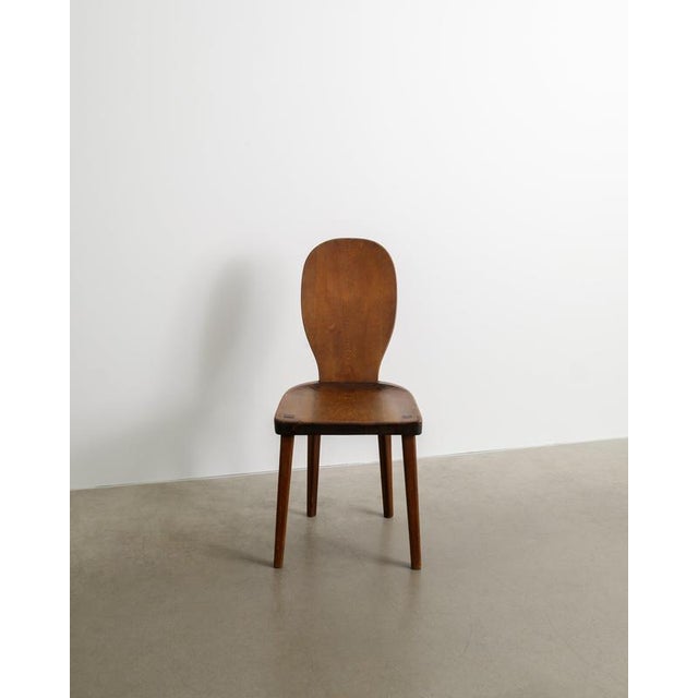 A rare and early swedish mid century modern wooden chair in dark brown stained pine with a sculptural shaped back designed...