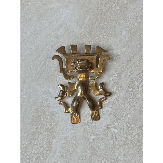 This vintage gold tribal pendant showcases striking pre-Columbian-inspired figural design, its stylized anthropomorphic...