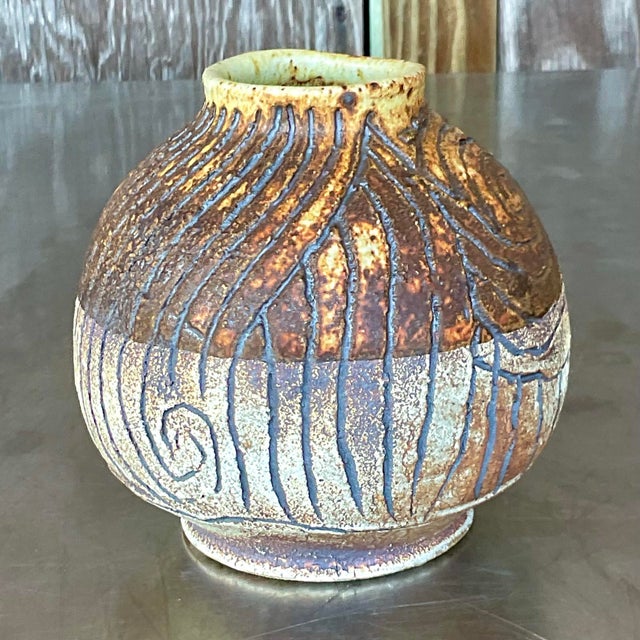 Elevate your decor with this Vintage Boho Studio Pottery Scored Vase. Crafted with American artistry, its textured design...