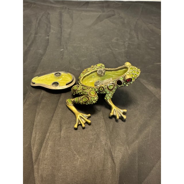 The Vintage Two's Company Crystal Enamel Pewter 3” Frog Trinket Box is a charming collectible piece that is handmade in...