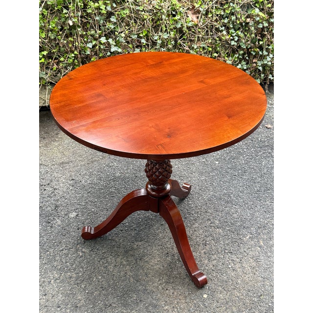Ethan Allen British classics lamp table in Cinnabar finish. Features a round top that sits on a pineapple carved pedestal...