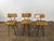 A striking set of three sculptural dining or accent chairs crafted from thick hand-carved solid wood with blackened iron...