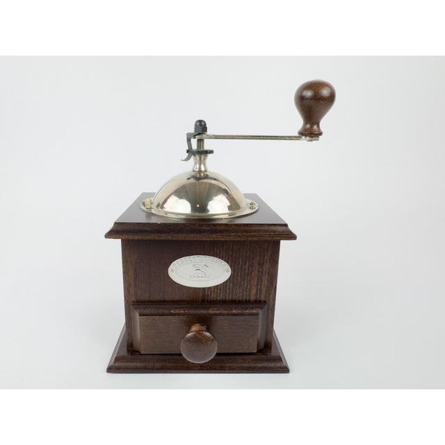 Vintage manual coffee grinder produced by Peugeot Frères, featuring a solid wooden body and a stainless steel (inox)...