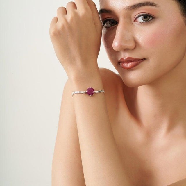 A timeless sterling silver bracelet centered around a striking natural ruby, cut in a classic round shape. Measuring 12 mm...