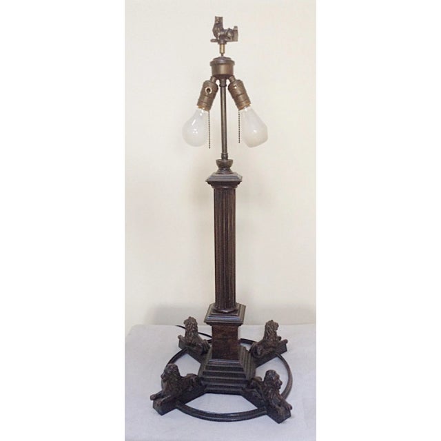 This bronze table lamp was four reclining lions as a base encircling a central fluted pillar. There are two sockets with...