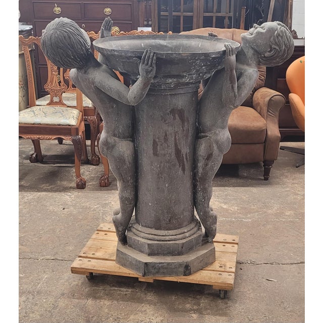 Vintage bronze bird bath after Edith Barretto Stevens. Features two children on a pedestal stretching their bodies looking...
