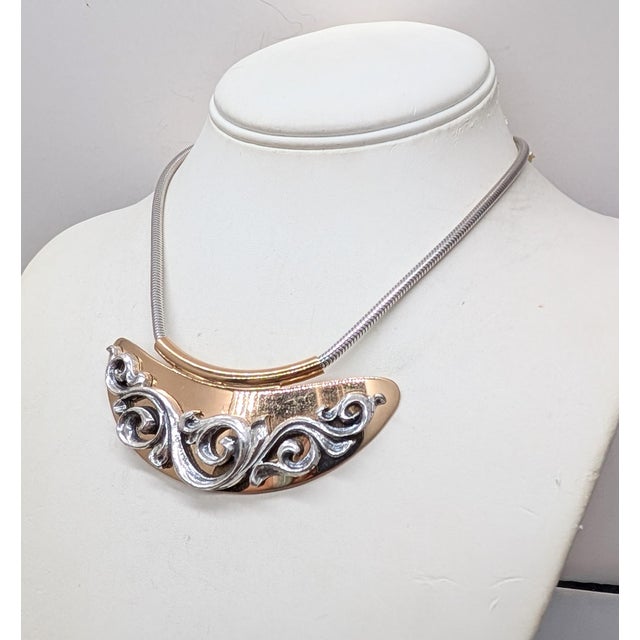 1975 goldtone small bib with rhodium plated stylized vines on a snake chain with spring ring clasp. Marked "NAPIER©" on...