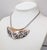 1975 goldtone small bib with rhodium plated stylized vines on a snake chain with spring ring clasp. Marked "NAPIER©" on...
