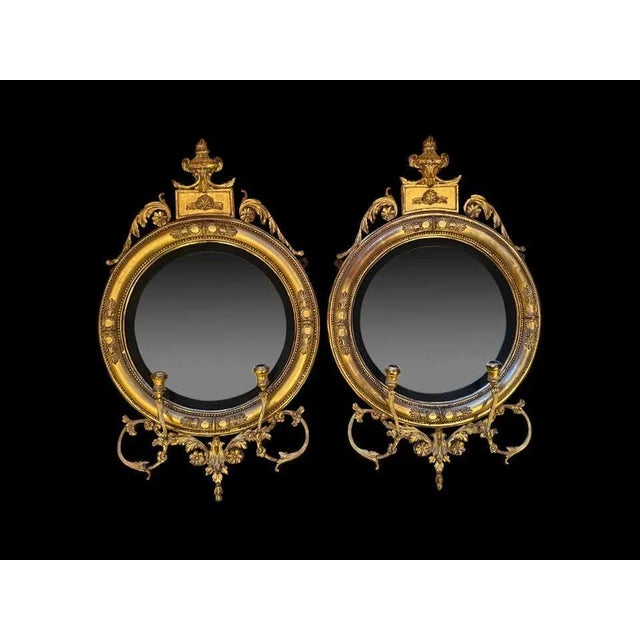 A fine pair of regency carved giltwood and gesso convex mirrors, english, circa 1820. On top is a wonderful pediment urn....