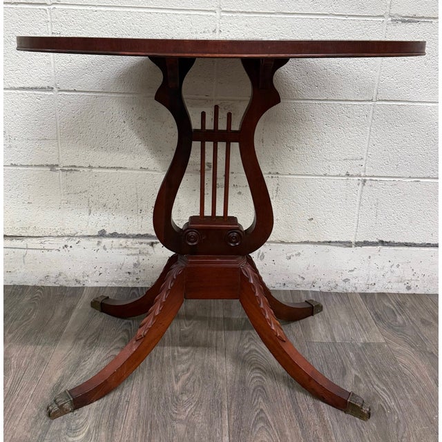 This is a beautiful vintage Duncan Phyfe style mahogany accent table featuring a classic lyre pedestal base, carved...