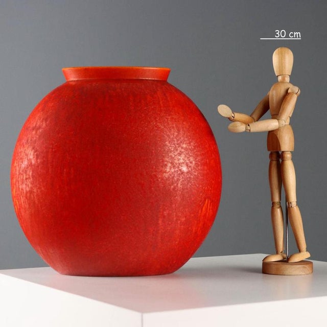 Cast glazed ceramic vase in shades of red and orange, manufacturer's trademark under the base. This piece is attributed to...