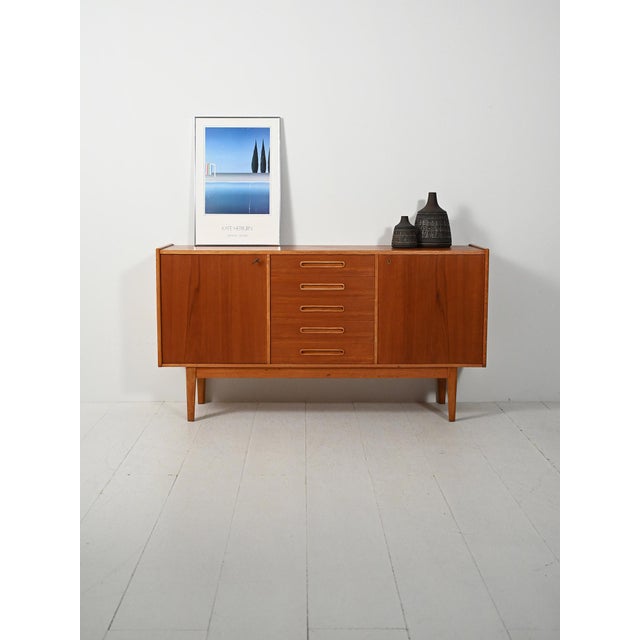 Scandinavian sideboard from the 1950s featuring a refined symmetrical composition, with central drawers and contrasting...
