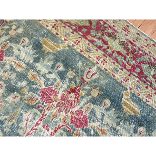 A late 19th century Persian Kerman with a matching repetitive floral design with animal figures on a green ground...