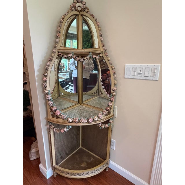 Vintage corner étagère / curio display in a Hollywood Regency taste, featuring mirrored back panels, a caned lower...