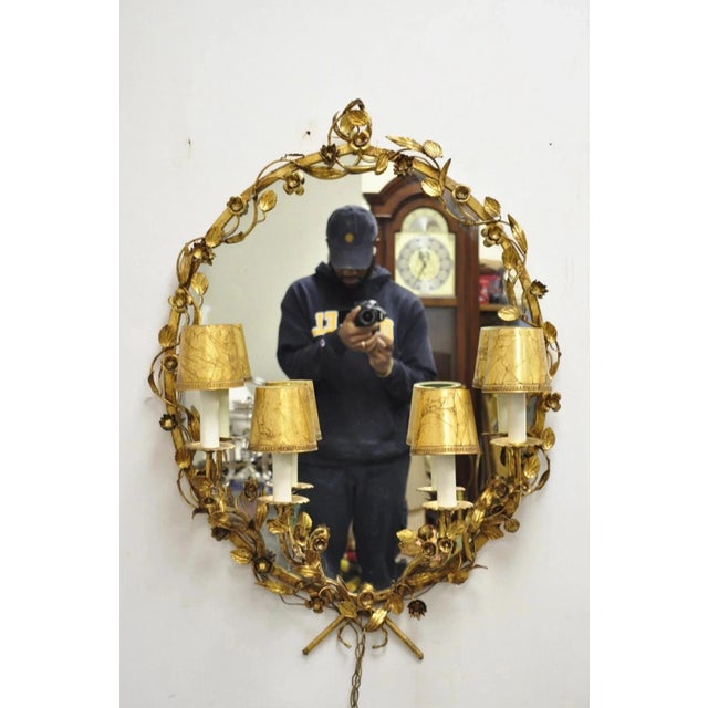 Vintage Italian Hollywood Regency Gold Gilt Iron Oval Floral Wall Mirror w/ Sconces. Item features oval central mirror,...