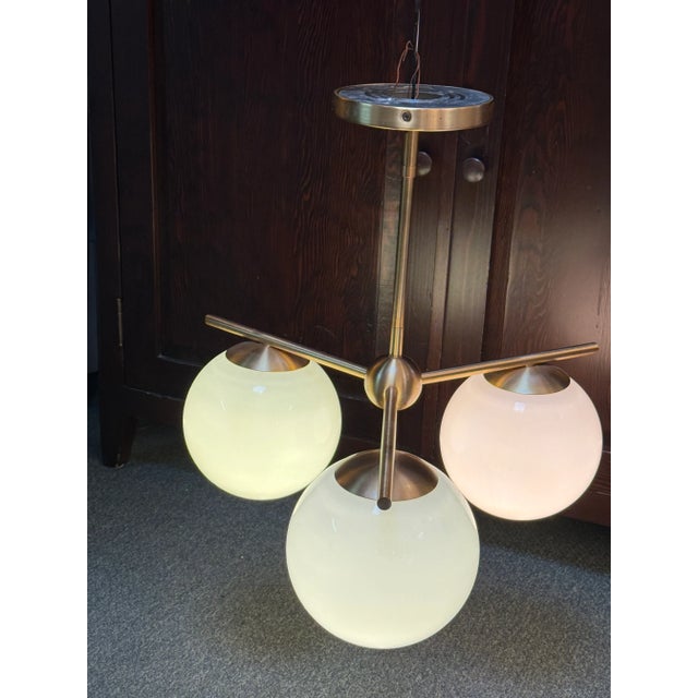 Design Plus Gallery presents a Sphere & Stem Chandelier by West Elm. Three milk glass globes, elevated with brushed brass,...
