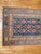 A narrow and long Persian runner with a floral design on a navy field, the border is green. Lot of different accent...