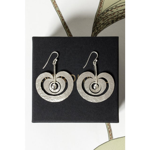 Enchanting silver earrings by Tapio Wirkkala, in the model “Omena” (“Apple”). Hand hammered silver sheets surround central...
